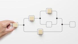 Business process and workflow automation with flowchart. Hand holding wooden cube block arranging processing management on white background