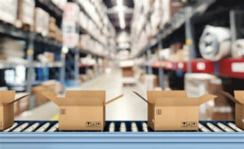 Cardboard boxes on conveyor rollers inside a warehouse ready to be shipped by courier for distribution.