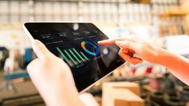 A worker is using tablet to review storage report.