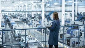 Engineer Monitoring and Analyzing Conditions at a Pristine Modern Electronics Factory with Automated Robot Hands Working with the Help of Artificial Intelligence Software. Getty Images