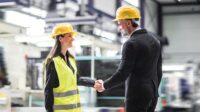 Female warehouse manager talking with logistics employee in warehouse, planning transport of products, goods, talking shipping process.