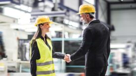 Female warehouse manager talking with logistics employee in warehouse, planning transport of products, goods, talking shipping process.