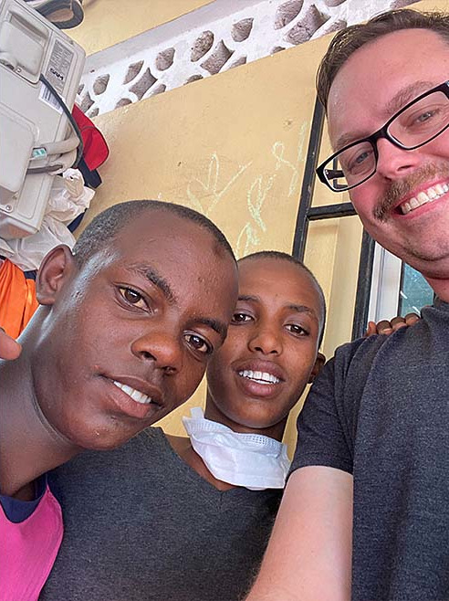 Justin Wise taking a selfie with two young men