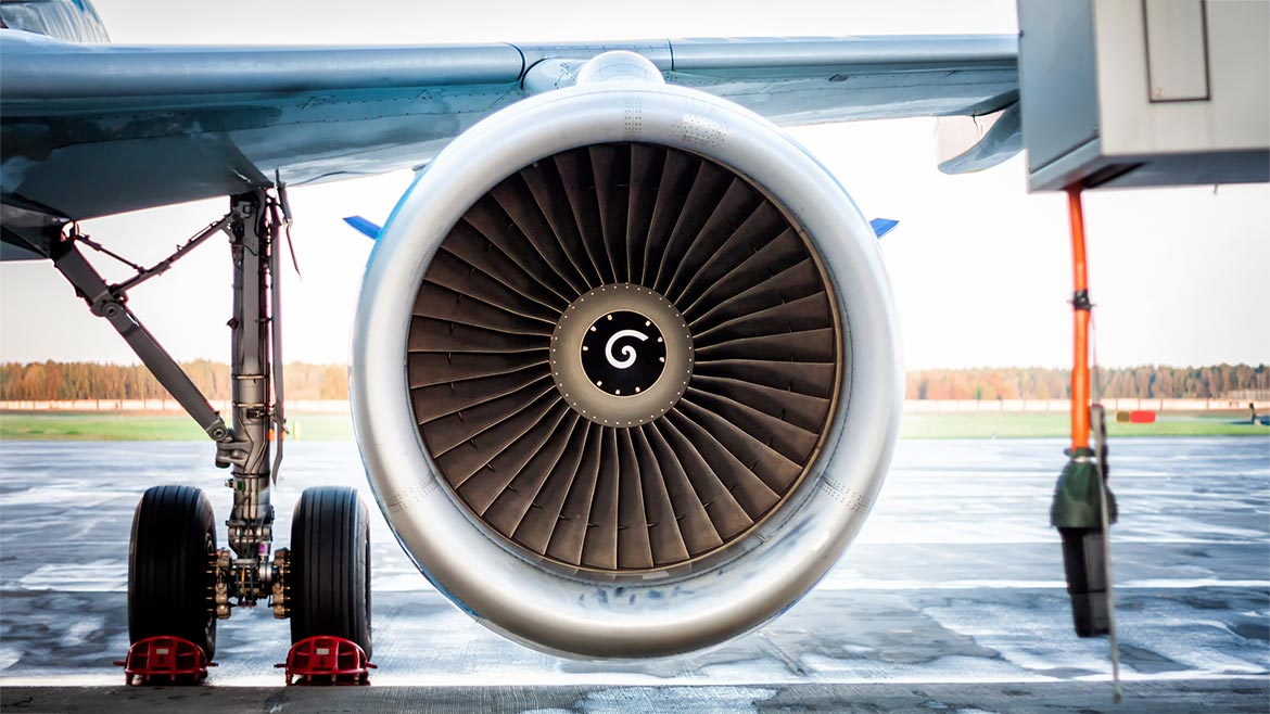 Close-up of engine and main landing gear of passenger airplane.