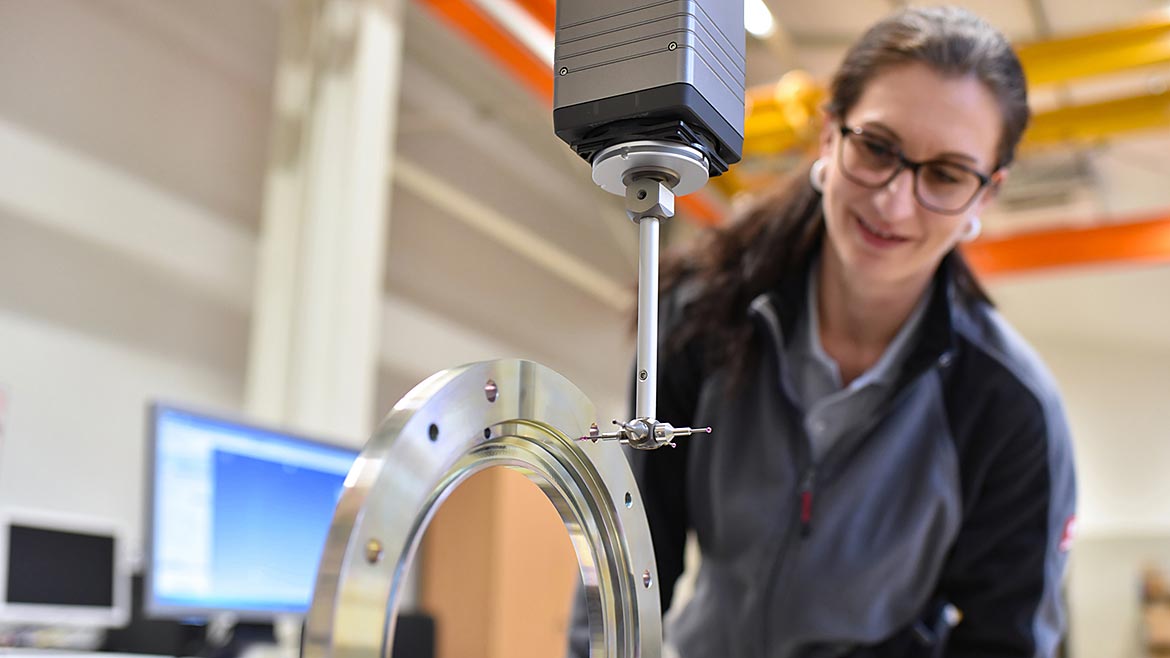 Woman working in quality control, measuring a workpiece.