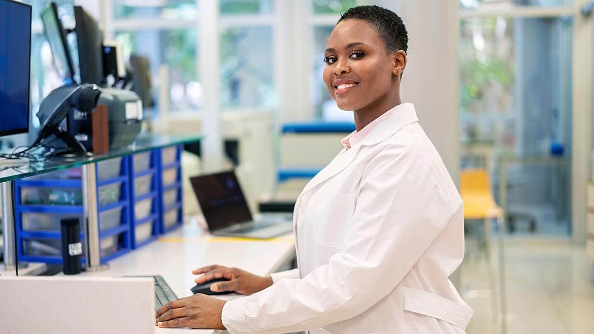 Woman scientist working on computer in a science lab.