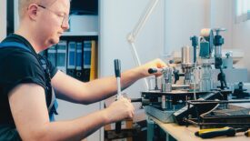 Professional calibration of pressure gauges and sensors. Working person sits at desk and is engaged in verification of instrumentation.