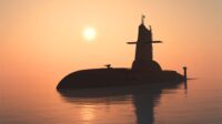 Surfaced submarine in the water at sunset